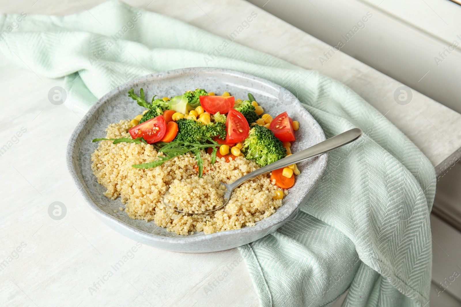 Photo of Plate with quinoa and different vegetables on table