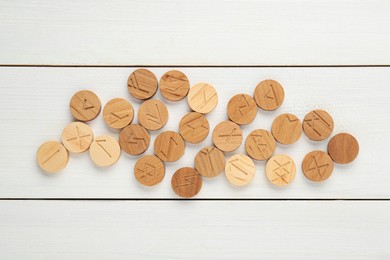 Photo of Runes with different symbols on white wooden table, flat lay