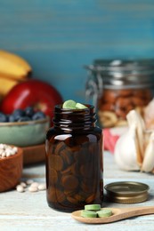Photo of Bottle of pills and foodstuff on white wooden table. Prebiotic supplements
