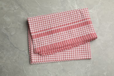 Photo of Red checkered kitchen towel on grey table, top view