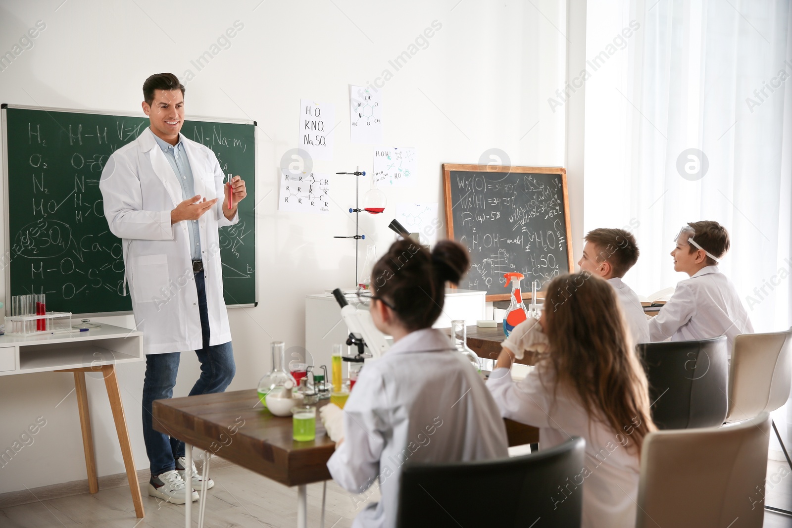 Photo of Teacher with pupils at chemistry lesson in classroom