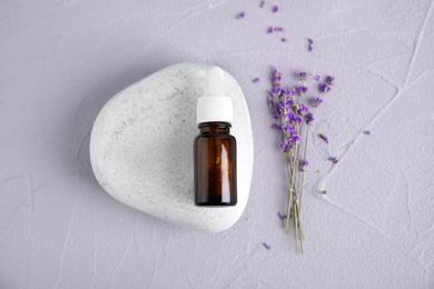 Photo of Flat lay composition with natural herbal oil and lavender flowers on color background
