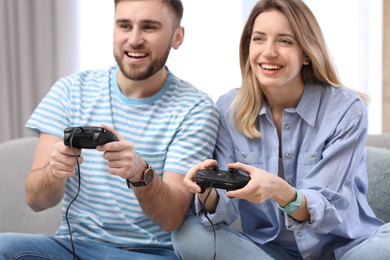 Photo of Young couple playing video game at home