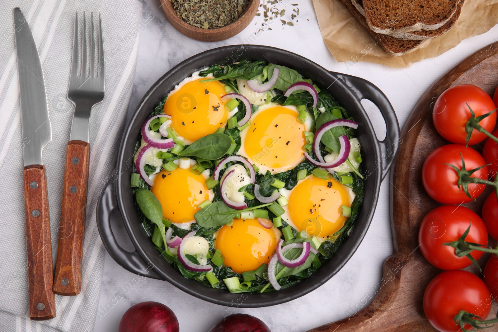 Photo of Tasty Shakshouka served on white marble table, flat lay