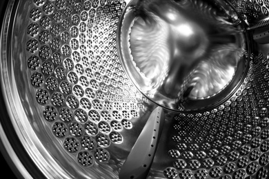 Photo of Empty washing machine drum, closeup view. Laundry day