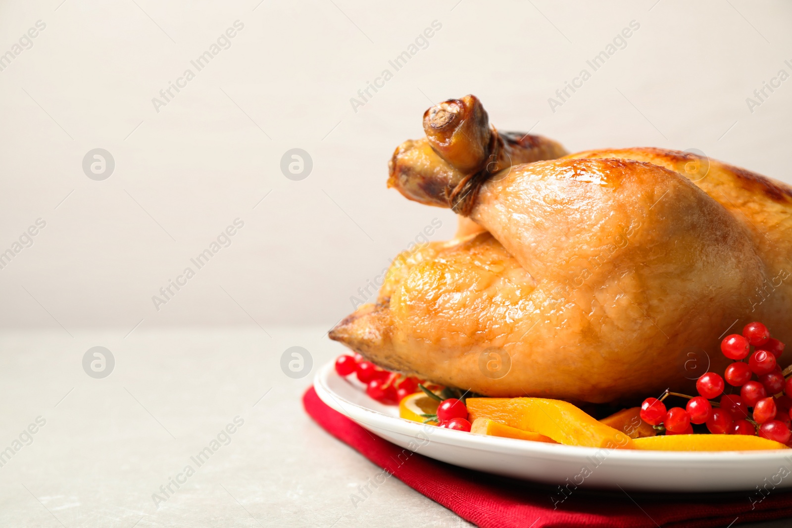 Photo of Delicious cooked turkey served on light table, closeup with space for text. Thanksgiving Day celebration