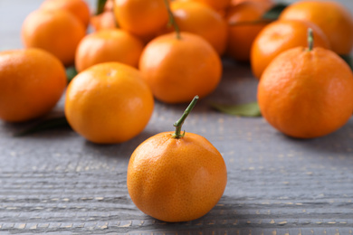 Photo of Fresh ripe tangerines on grey wooden table