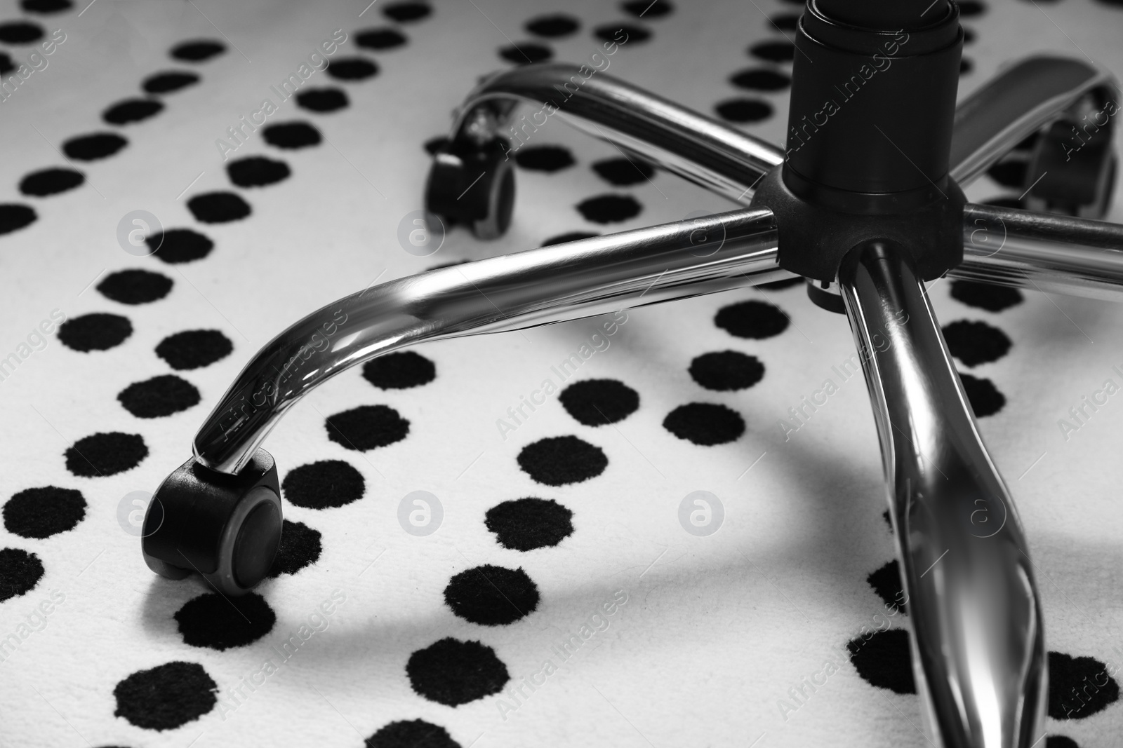 Photo of Modern office chair on carpet indoors, closeup. Base with casters