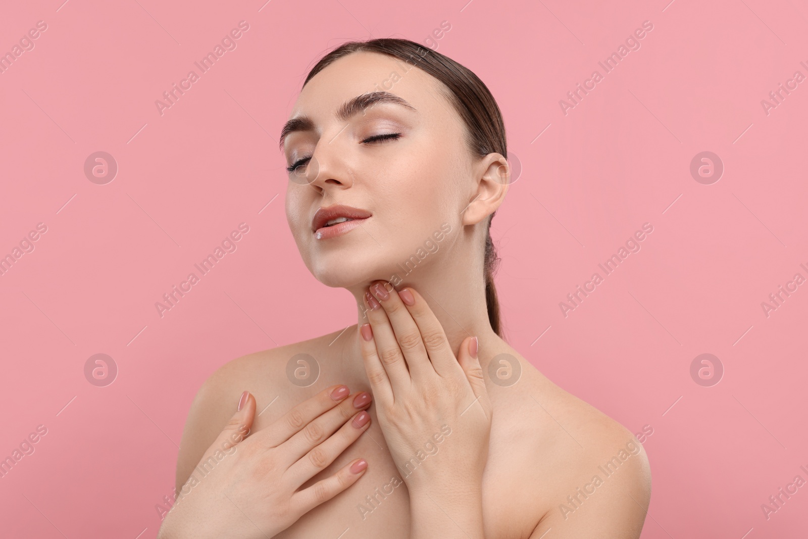 Photo of Beautiful woman touching her neck on pink background