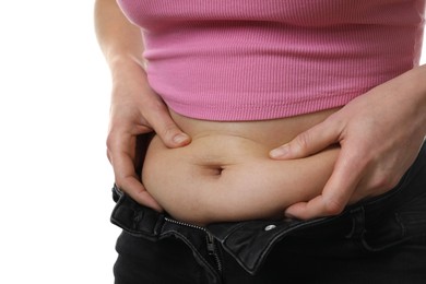 Woman touching belly fat on white background, closeup. Overweight problem