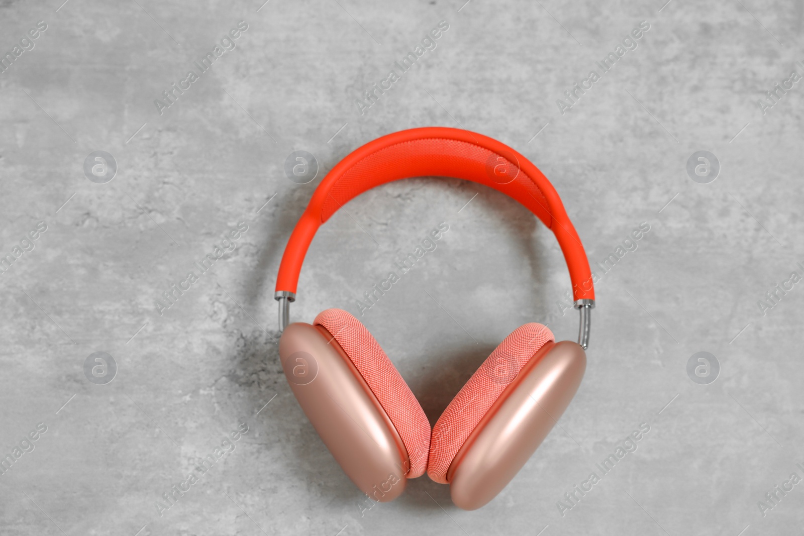 Photo of Stylish pink headphones on light grey table, top view