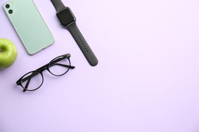 Photo of Flat lay composition with stylish smart watch on violet background. Space for text
