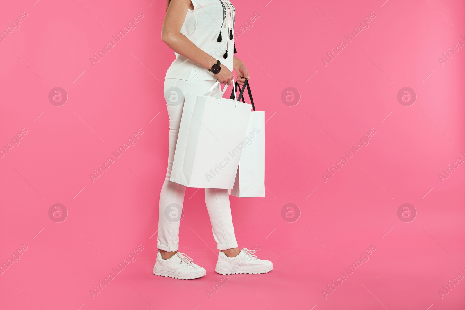 Photo of Woman with paper shopping bags on color background. Mock up for design