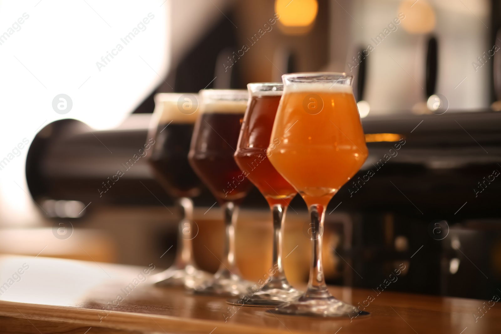 Photo of Different beers in glasses on bar counter