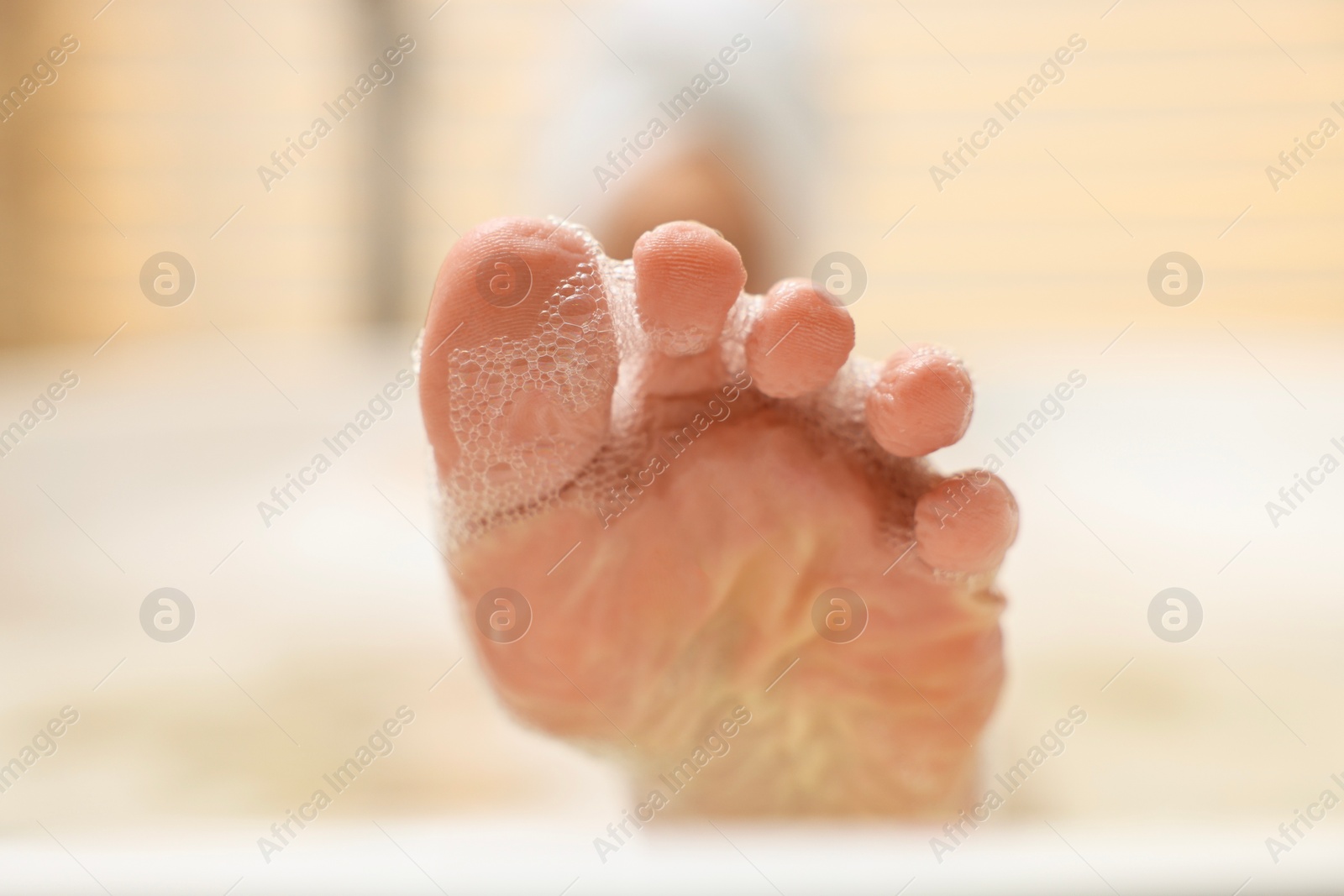 Photo of Woman taking bath with foam in tub, closeup