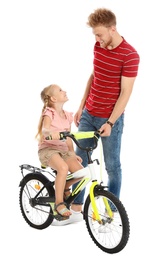 Photo of Young father teaching daughter to ride bicycle on white background