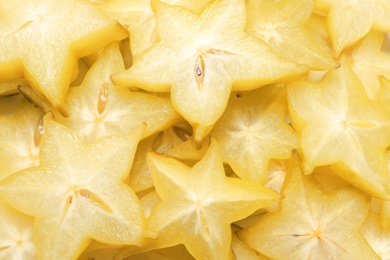 Photo of Pile of delicious carambola slices as background, top view