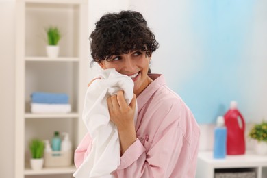 Beautiful woman with clean laundry at home