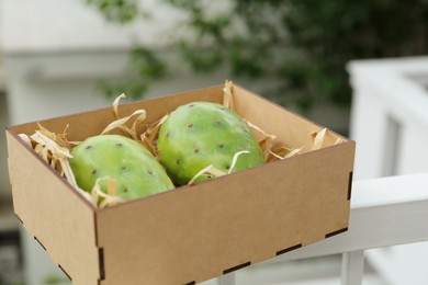Photo of Delicious fresh ripe opuntia fruits in wooden box outdoors