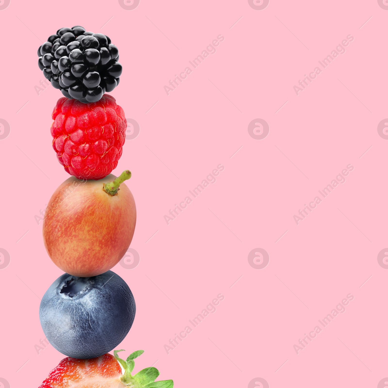 Image of Stack of different fresh tasty berries on pink background, space for text