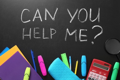 Photo of Flat lay composition with school supplies and phrase "Can you help me?" on chalkboard