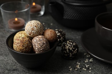 Different delicious vegan candy balls on grey table