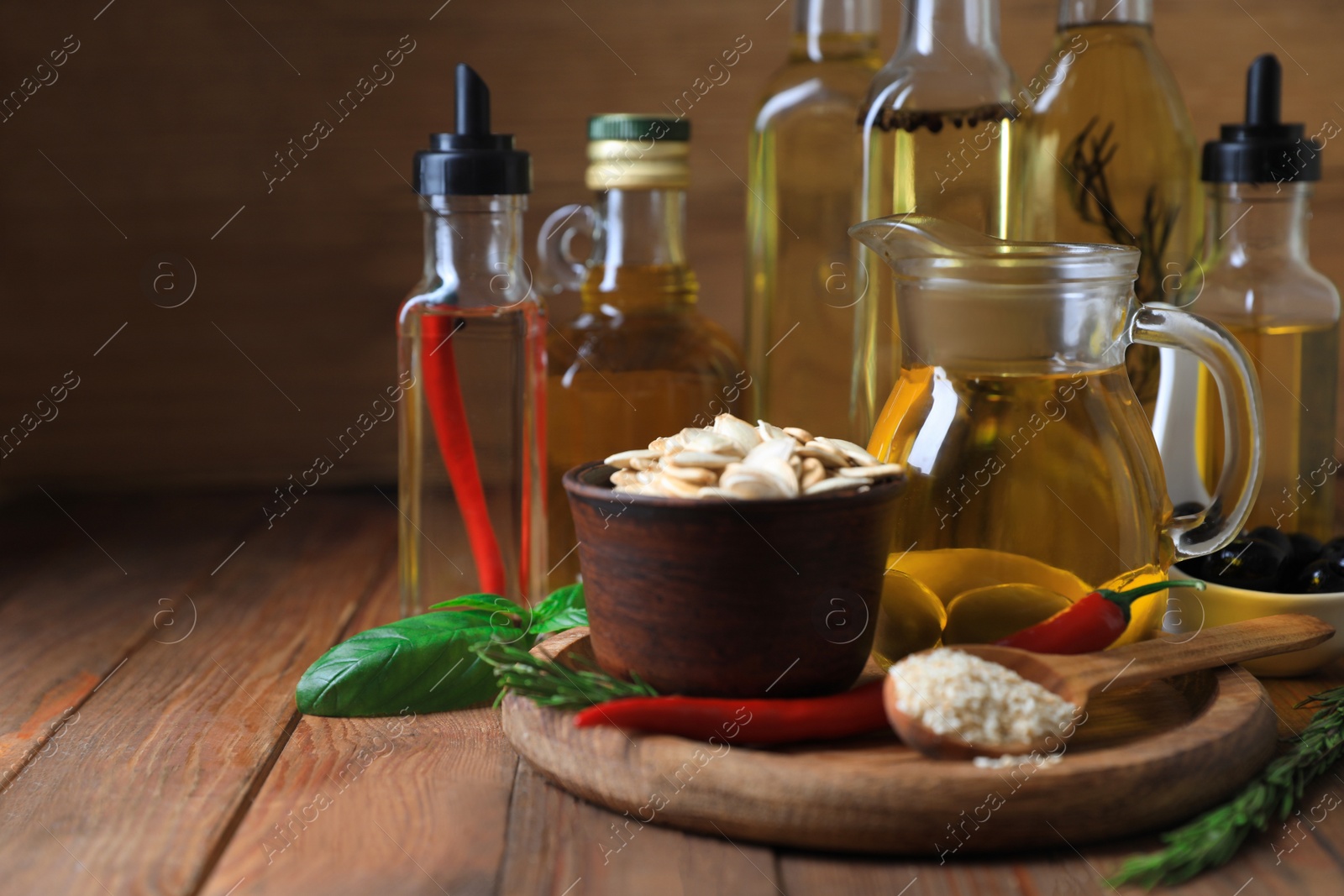 Photo of Different cooking oils and ingredients on wooden table