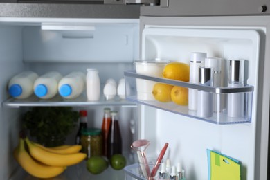 Photo of Storage of cosmetics in refrigerator door bins next to groceries