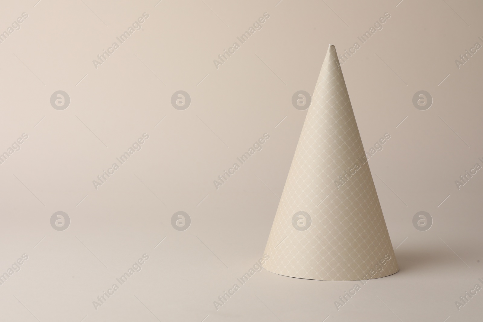 Photo of One beautiful party hat on beige background. Space for text