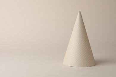 One beautiful party hat on beige background. Space for text