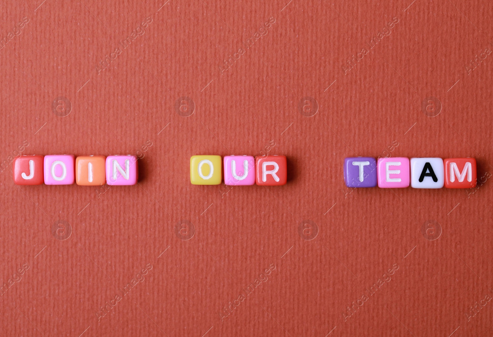 Photo of Colorful cubes with phrase Join Our Team on red background, flat lay. Recruiter searching employee