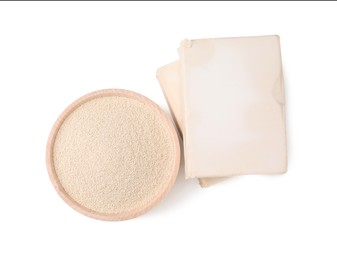 Photo of Compressed and granulated yeast on white background, top view