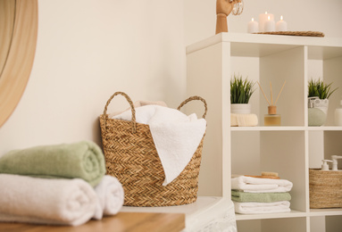 Fresh towels on wooden table in bathroom