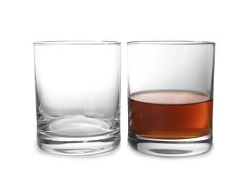 Empty and full whiskey glasses on white background