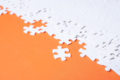 Photo of Blank white puzzle pieces on orange background