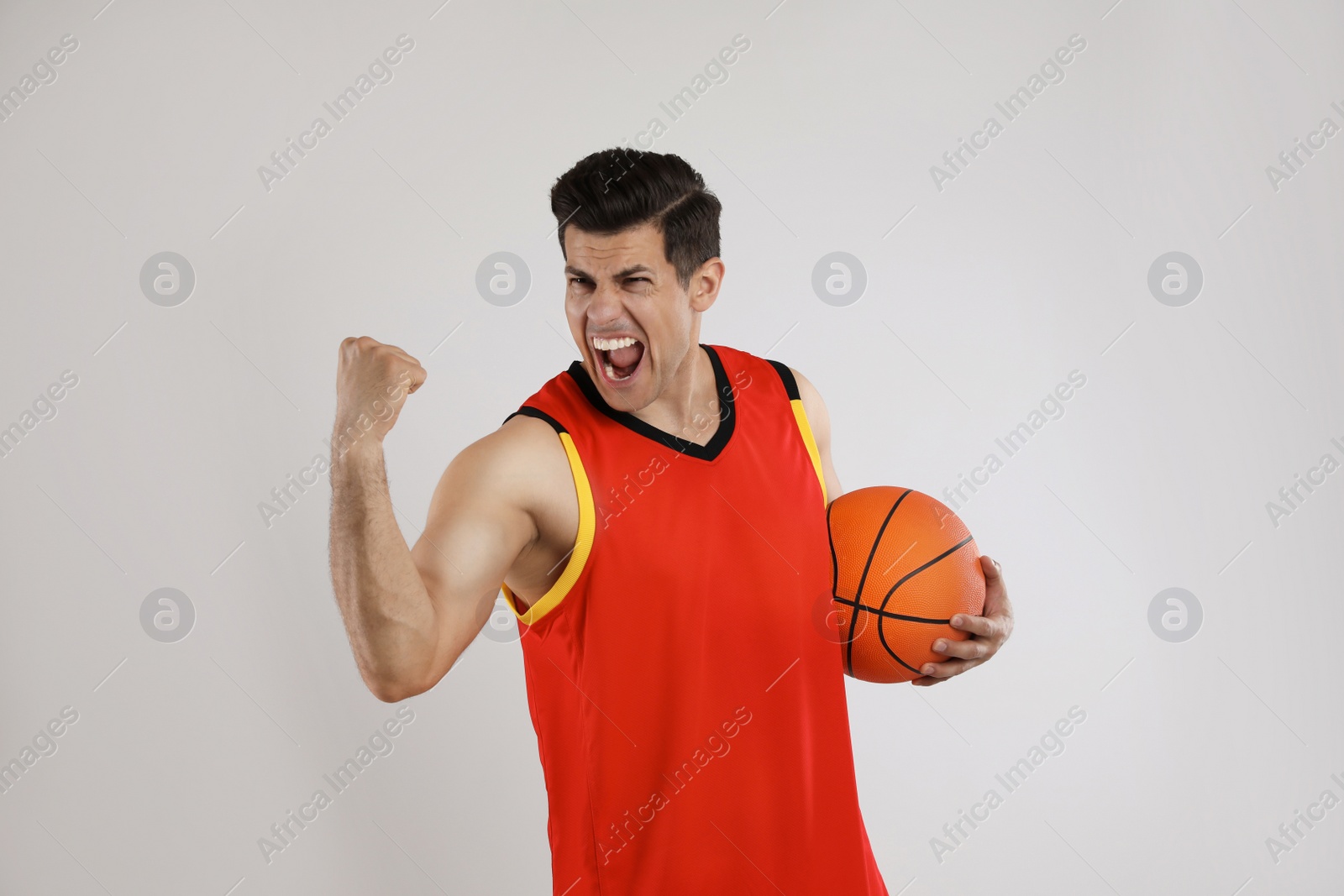 Photo of Basketball player with ball on grey background