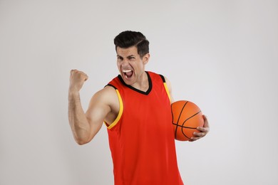 Basketball player with ball on grey background