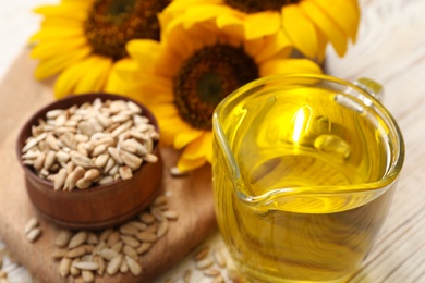 Photo of Sunflower oil in glass jug on table, closeup. Space for text