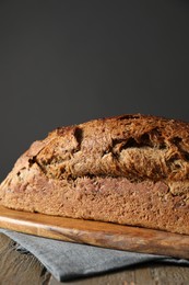 Photo of Freshly baked sourdough bread on wooden table, closeup