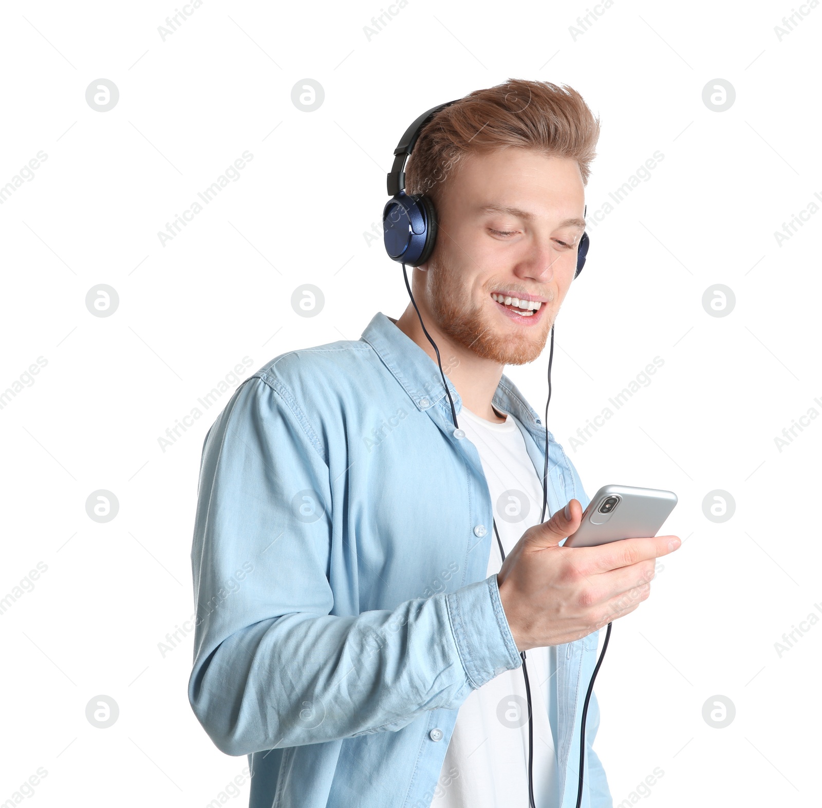 Photo of Handsome young man listening to music with headphones on white background