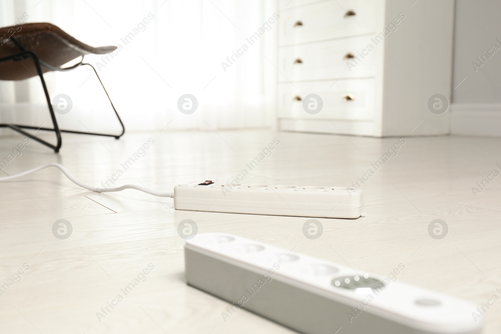 Photo of Extension cords on floor indoors, space for text. Electrician's professional equipment