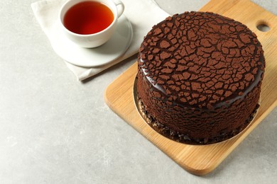 Delicious chocolate truffle cake and tea on light grey table, space for text