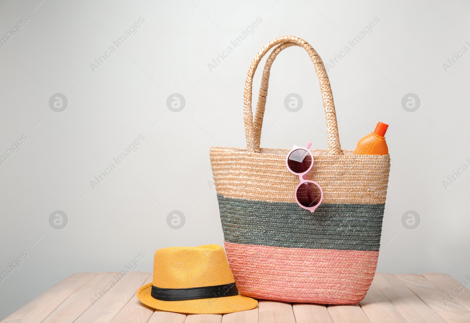 Photo of Bag with beach objects on table against light background