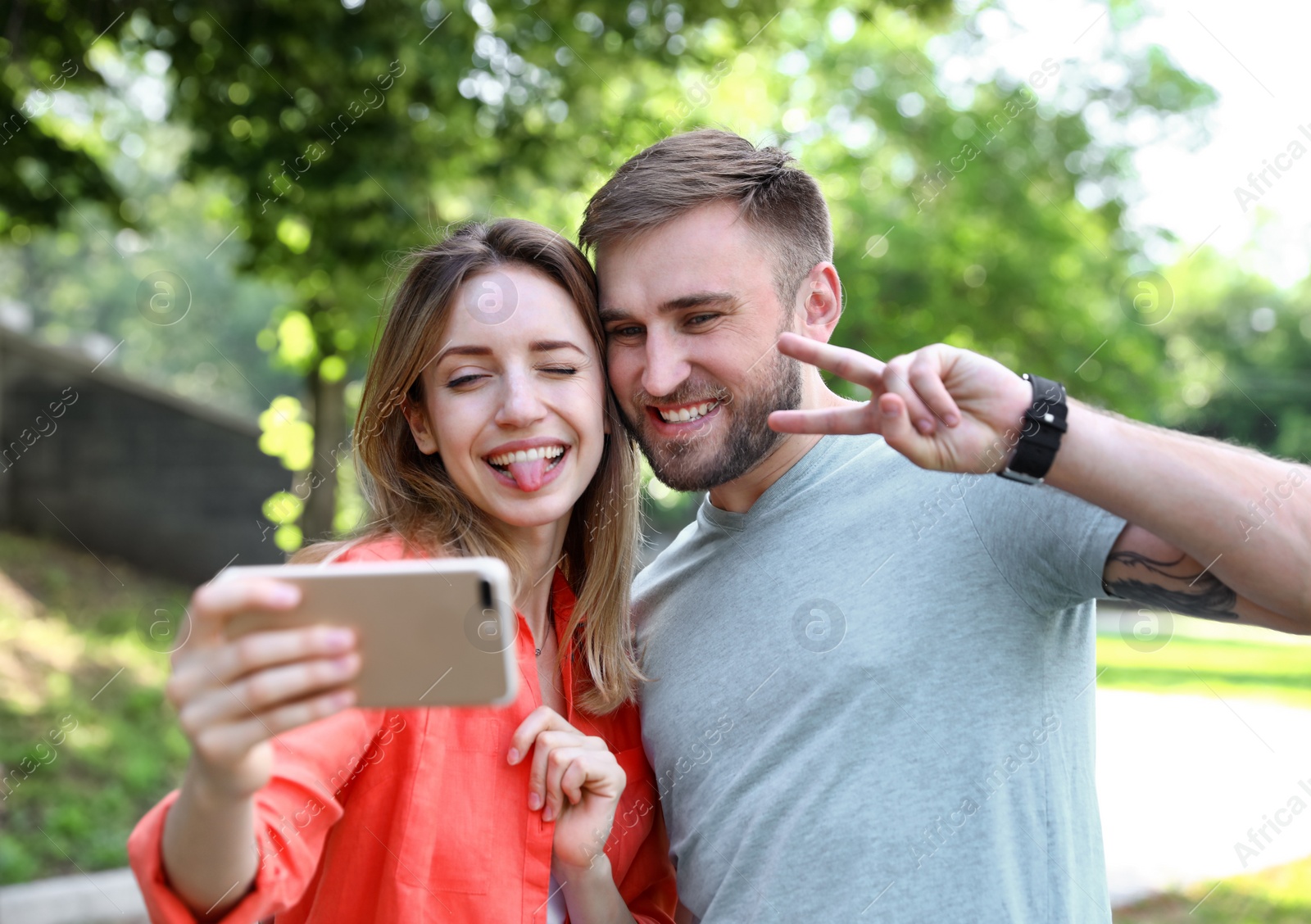 Photo of Happy young couple taking selfie in park