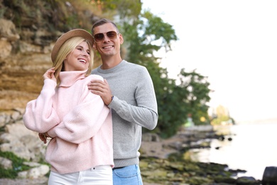 Photo of Happy couple in stylish sweaters on beach