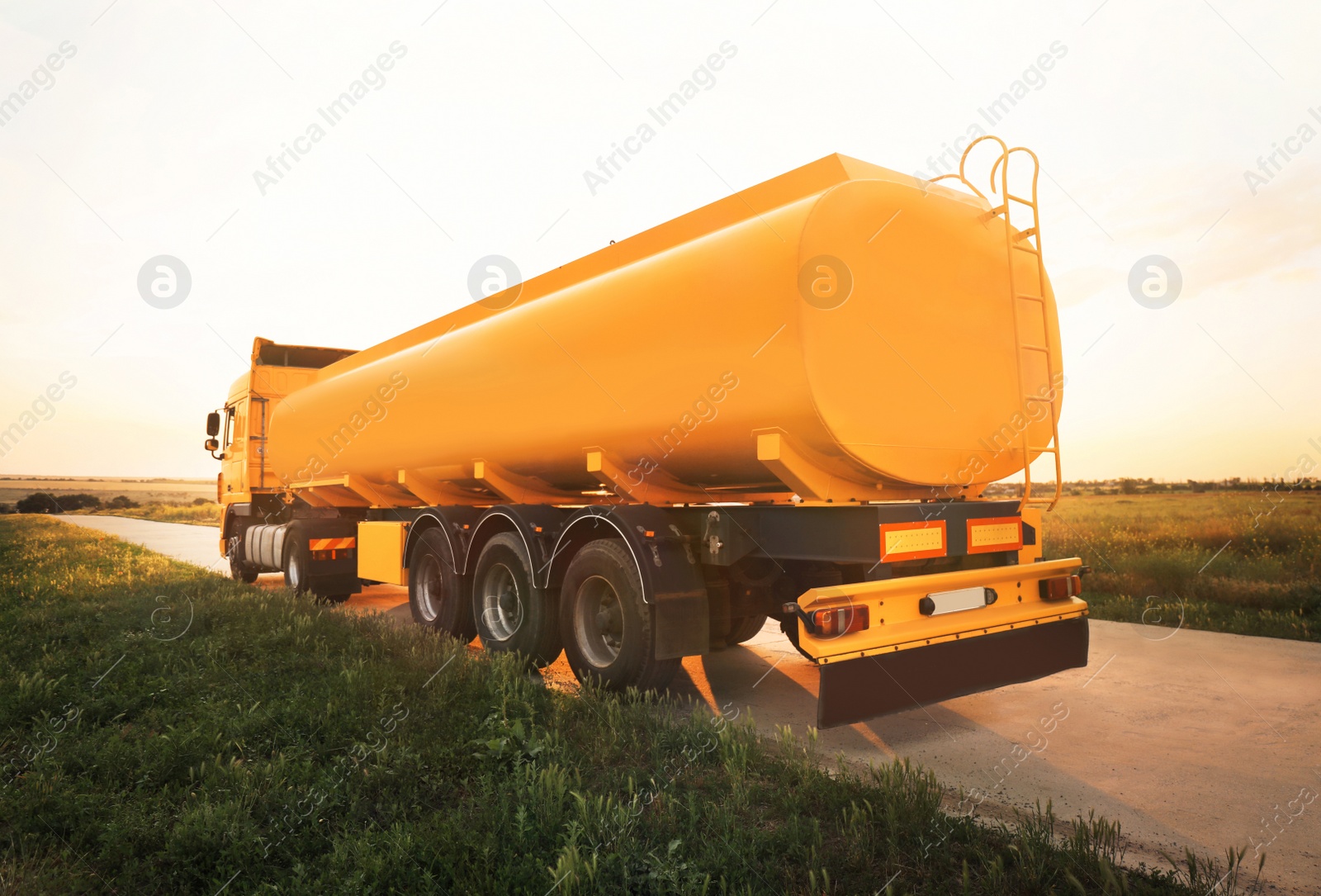 Photo of Modern yellow truck parked on country road
