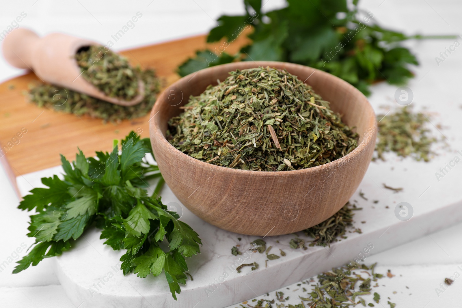 Photo of Dried parsley and fresh leaves on table, closeup