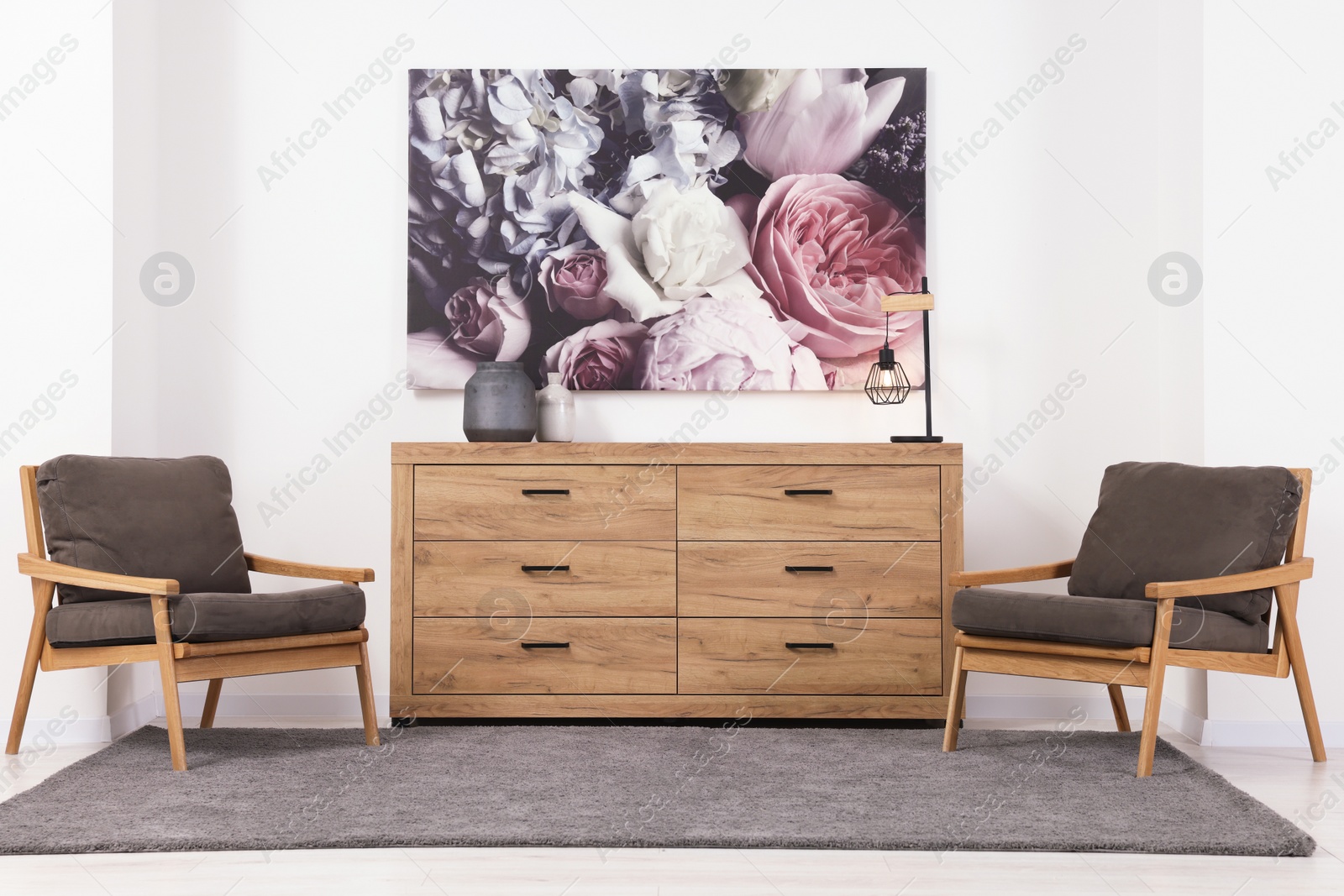 Photo of Stylish living room with wooden chest of drawers, armchairs and beautiful picture. Interior design