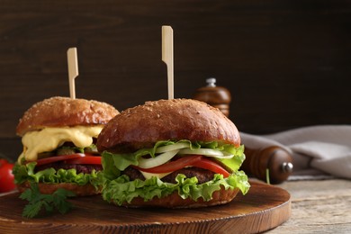 Photo of Delicious vegetarian burgers served on wooden table