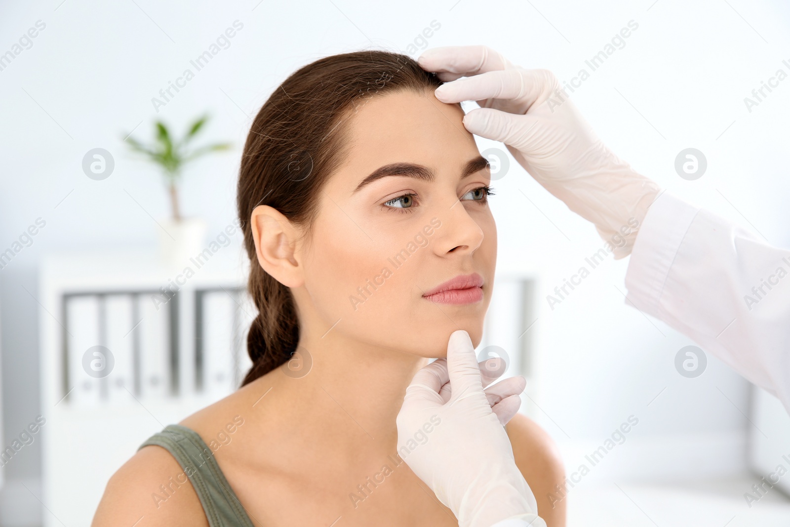 Photo of Dermatologist examining patient's face in clinic. Skin cancer checkup